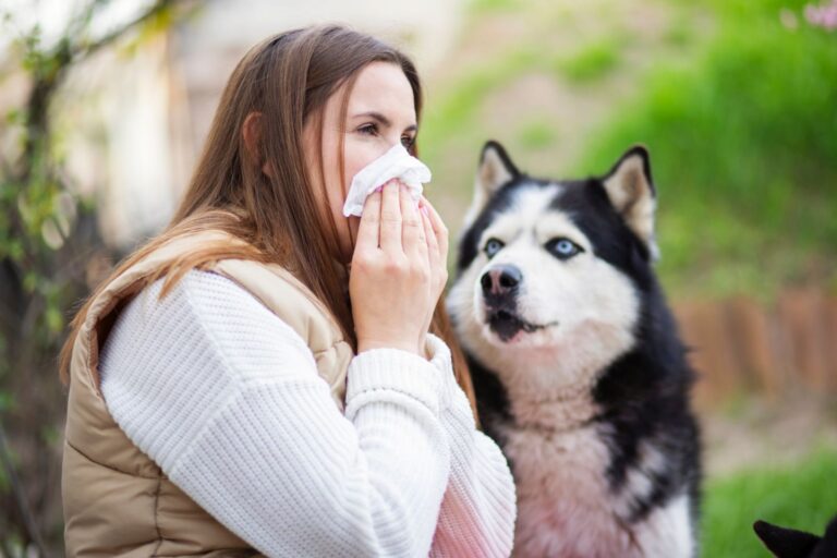 femme allergique aux poils de chien qui se mouche